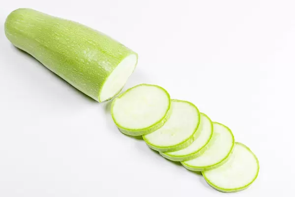 Fresh green zucchini with slice on white background