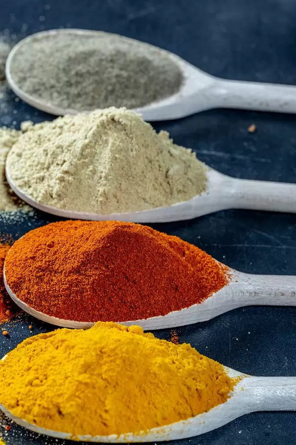 Fresh ground spices in wooden spoons