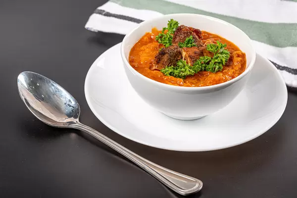 Fresh homemade orange soup with vegetables and chicken fillet