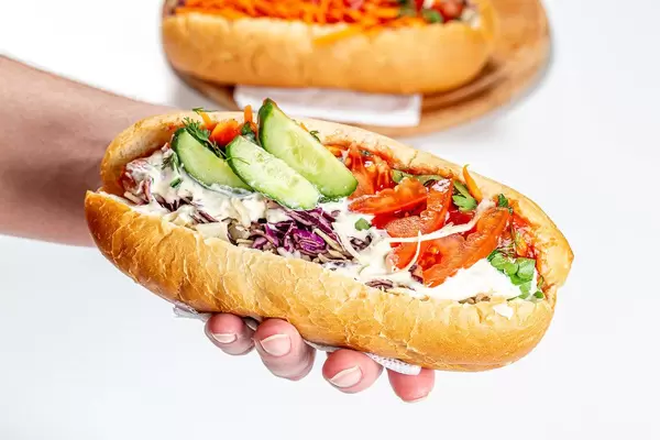 Fresh hot dog in a man's hand