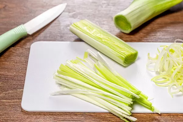 Fresh leek on kitchen Board with ceramic knife (Flip 2019)