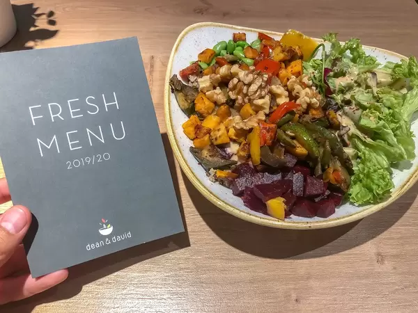 Fresh Menu - Meükarte von Dean&David, neben der der Veggie Buddha Bowl mit gegrilltem Gemüse, Rote Beete, Walnüssen und Salat