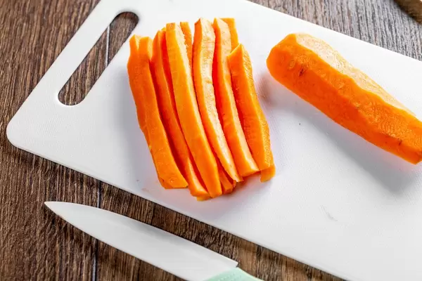 Fresh orange sliced carrots with a knife on the table (Flip 2019)