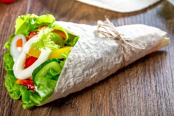 Fresh pita bread with lettuce, tomatoes, bell peppers, onions, carrots and cucumber (Flip 2019)
