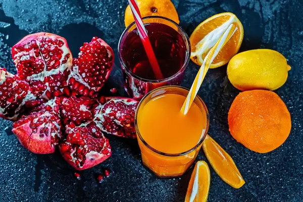 Fresh pomegranate and orange juice with ripe fruit