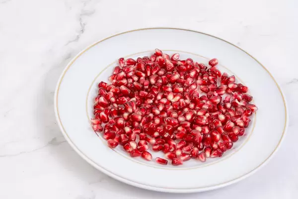 Fresh Pomegranate on the plate above grey marble table