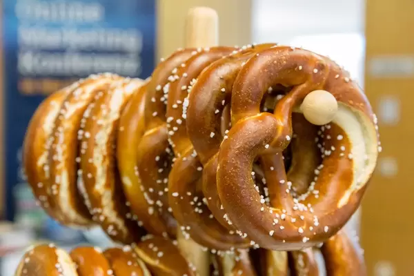 Fresh pretzel with salt on a wooden stand during breakfast time at AXA's OMWest19 Barcamp in Cologne, Germany