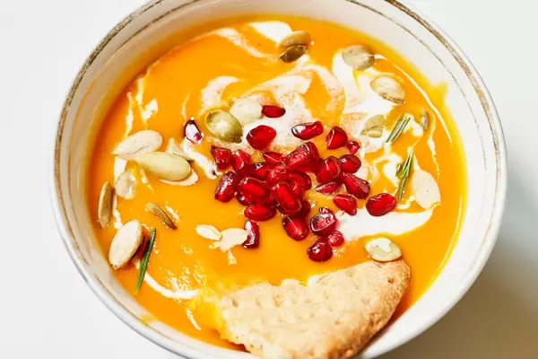 Fresh pumpkin soup topped with pomegranate seeds