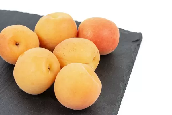Fresh raw Apricots on the black stone tray background (Flip 2019)