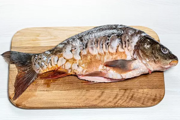 Fresh raw carp on kitchen Board