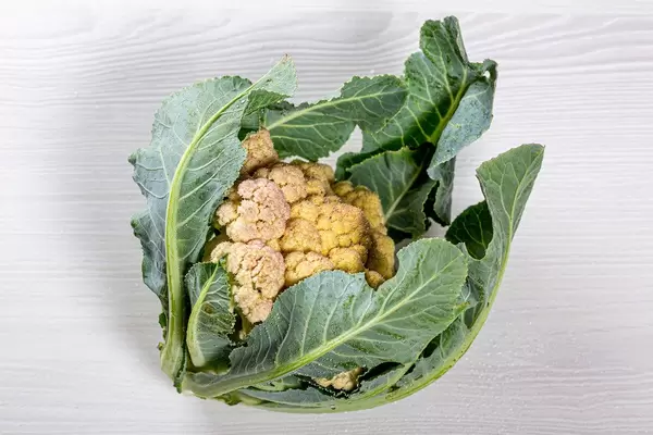 Fresh raw cauliflower on white wooden background
