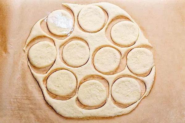 Fresh raw dough with the cut out circles. Top view