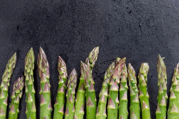 Fresh raw green asparagus on black background (Flip 2019)