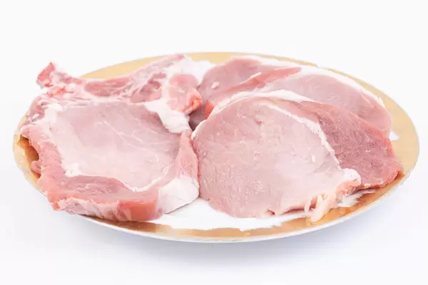 Fresh Raw Pork Chops on the plate above white background