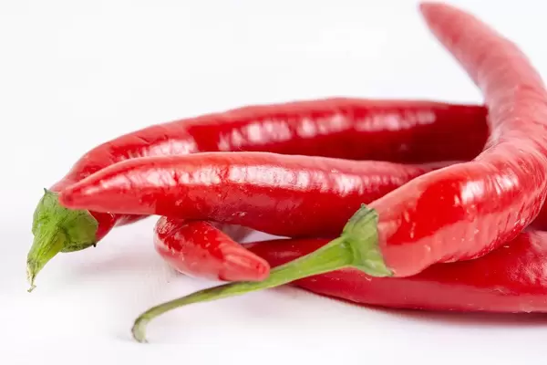 Fresh Red Hot Chilli Peppers above white background