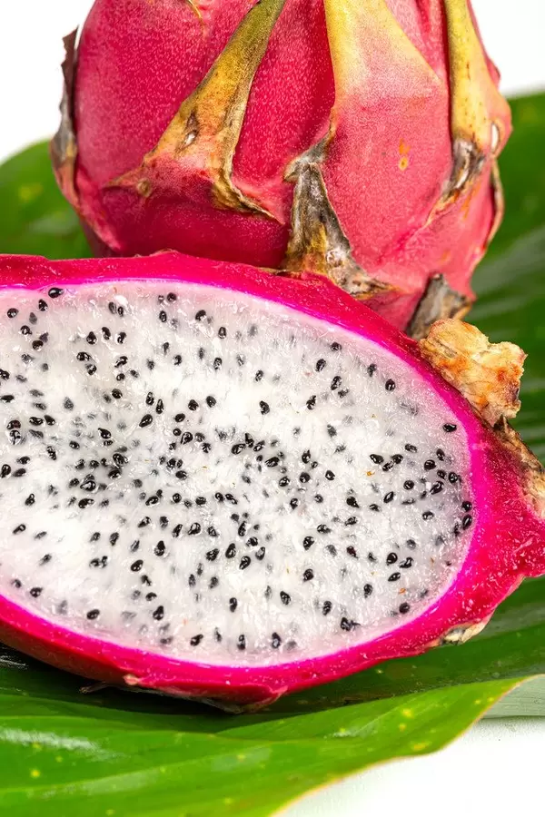 Fresh ripe dragon fruit on green wet leaf