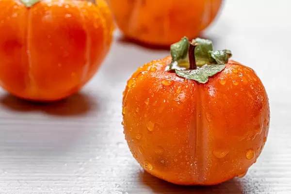 Fresh ripe orange persimmons with water drops (Flip 2019)