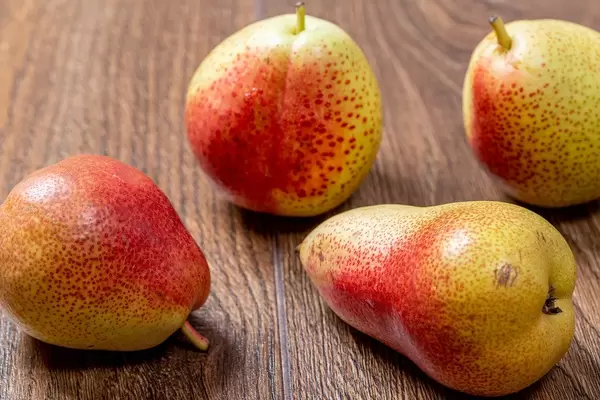 Fresh ripe pears on brown wooden background