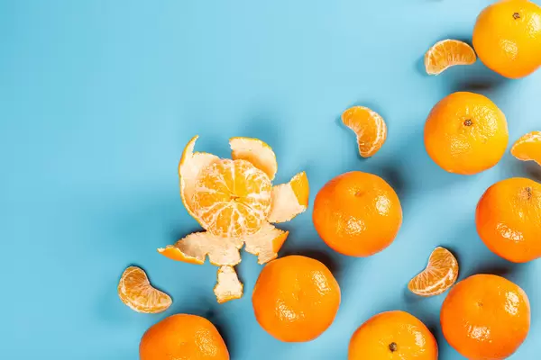 Fresh ripe tangerines on blue background