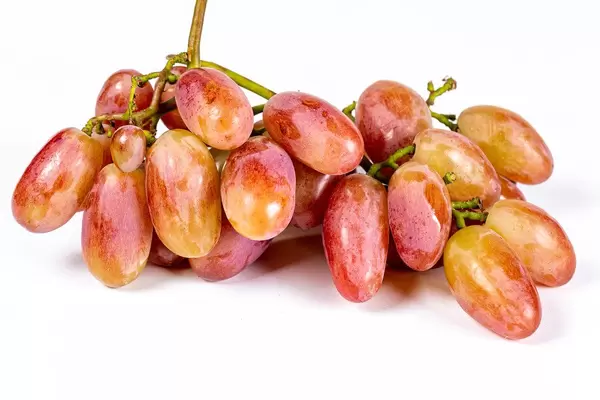Fresh ripe yellow-pink grapes on white