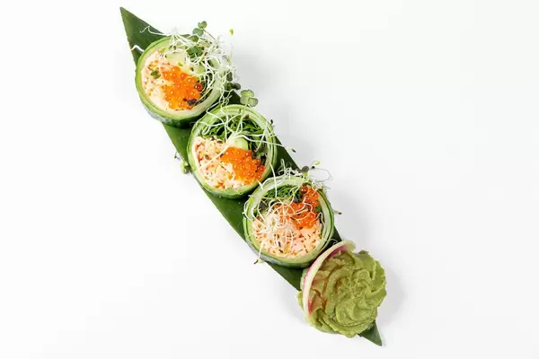 Fresh rolls with cucumber, avocado, crab, arugula and micro-greens on a large green leaf. Top view (Flip 2019)