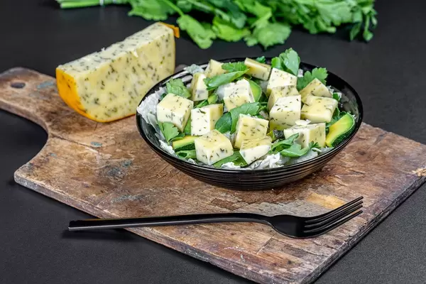 Fresh salad with herbs, avocado, cheese and garlic on a black background (Flip 2020)
