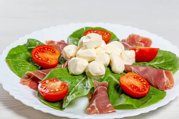 Fresh salad with jamon, mozzarella, tomatoes and Romaine lettuce