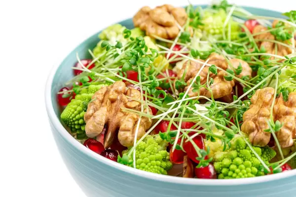Fresh salad with walnuts, pomegranate and watercress, close-up
