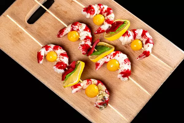 Fresh shrimp skewers on a wooden kitchen board