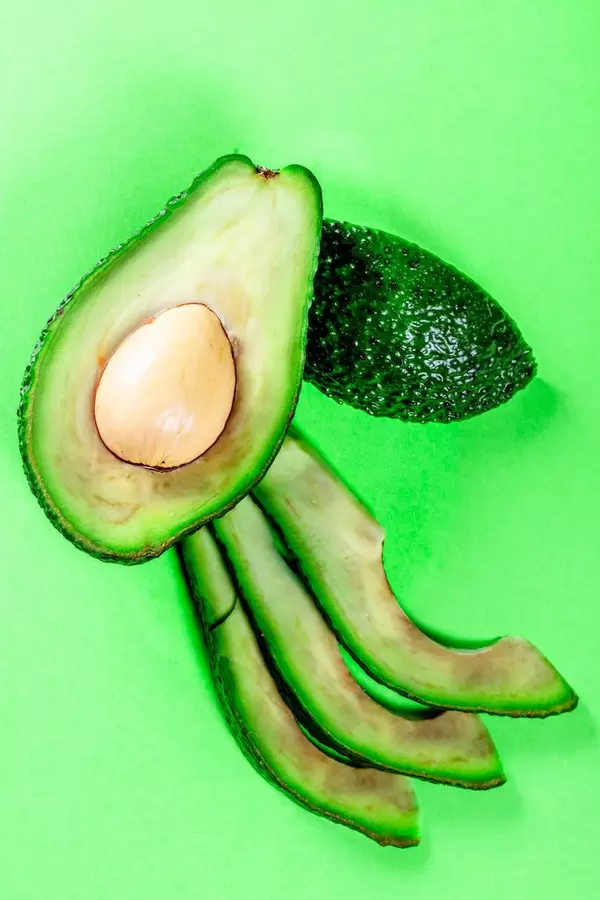 Fresh Sliced avocado on green background