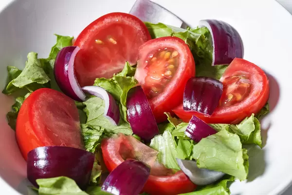 Fresh vegetable salad with tomato, lettuce and red onion
