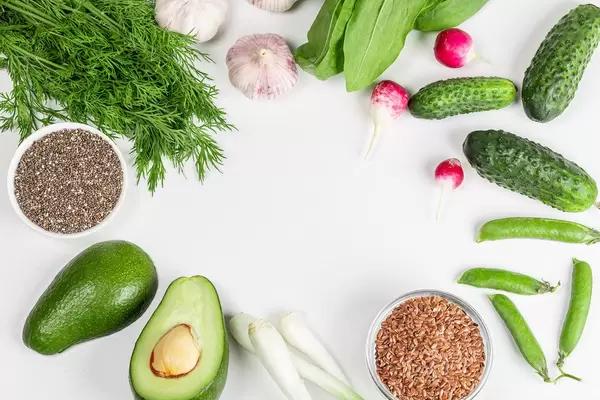 Fresh vegetables, greens with chia and flax seeds on a white background. The concept of diet food. Free space