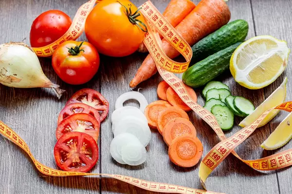Fresh vegetables with measuring tape on the table. Healthy eating concept
