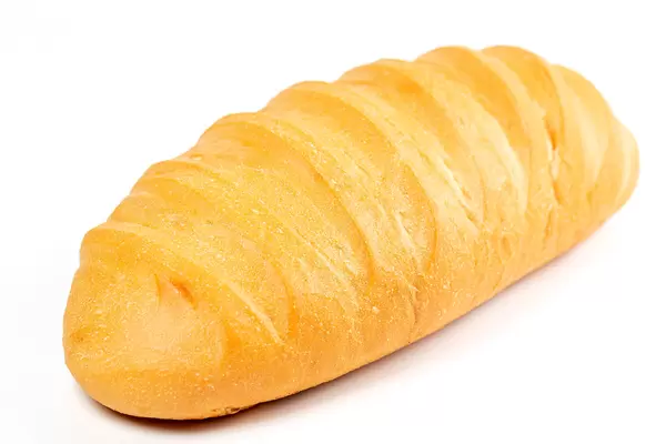 Fresh wheat loaf on white, close-up