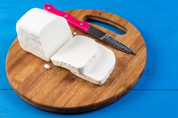 Fresh White Cheese on the round wooden board (Flip 2019)