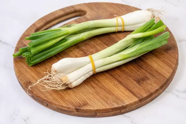 Fresh young Onion on the wooden board (Flip 2019)