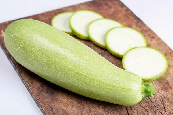 Fresh young zucchini on an old kitchen board, close-up
