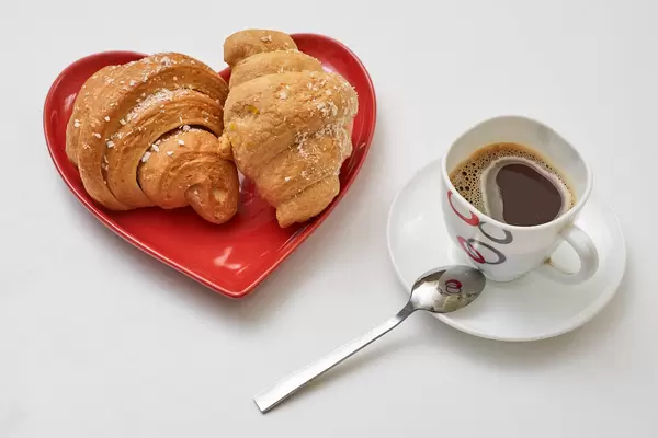 Freshly baked croissants and a mug of black coffee