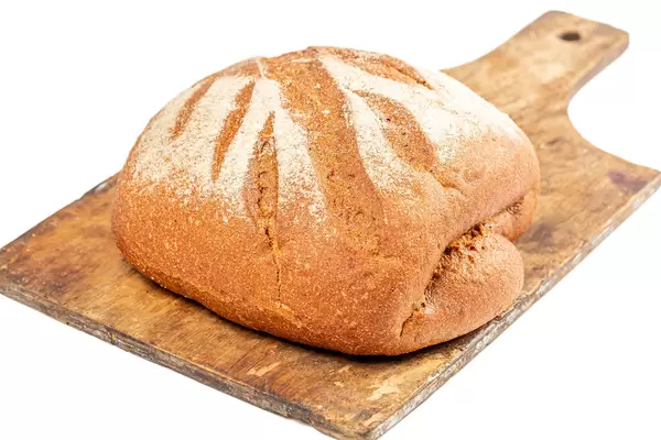 Freshly baked traditional bread on old wooden kitchen board