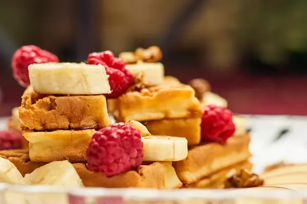 Freshly baked waffles with raspberries and bananas