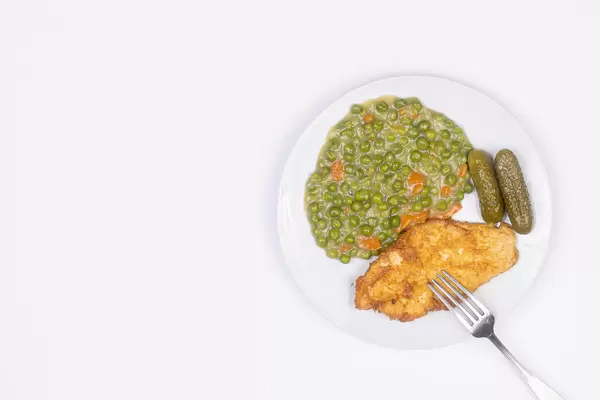 Fried Chicken breasts with cooked Green Peas with copy space
