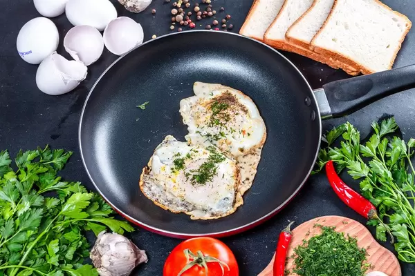 Fried chicken eggs with greens in a frying pan (Flip 2019)