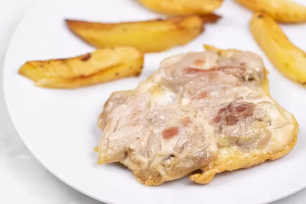 Fried Chicken meat served with fried potatoes on the plate