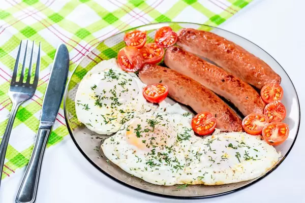 Fried eggs and fried sausage for breakfast.
