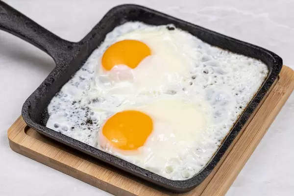 Fried Eggs in the hard black frying pan