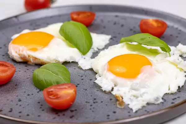 Fried Eggs served with Cherry tomatoes and Basil