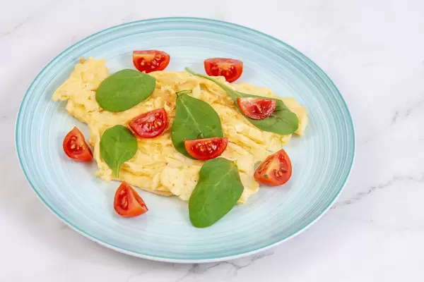 Fried Eggs with Baby Spinach and Cherry Tomato on the plate