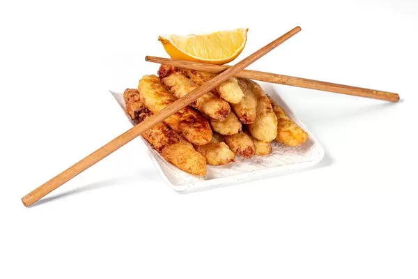 Fried fish sticks with a slice of lemon and chopsticks