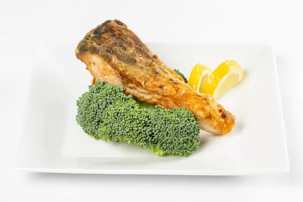 Fried fish with fresh broccoli and lemon