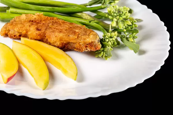 Fried fish with mango and broccolini, close-up